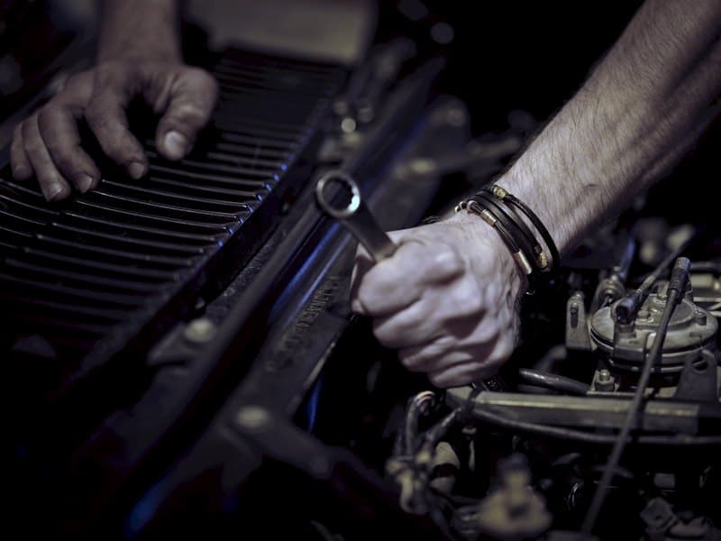 Mechanic working on a vehicle engine in the repair bay